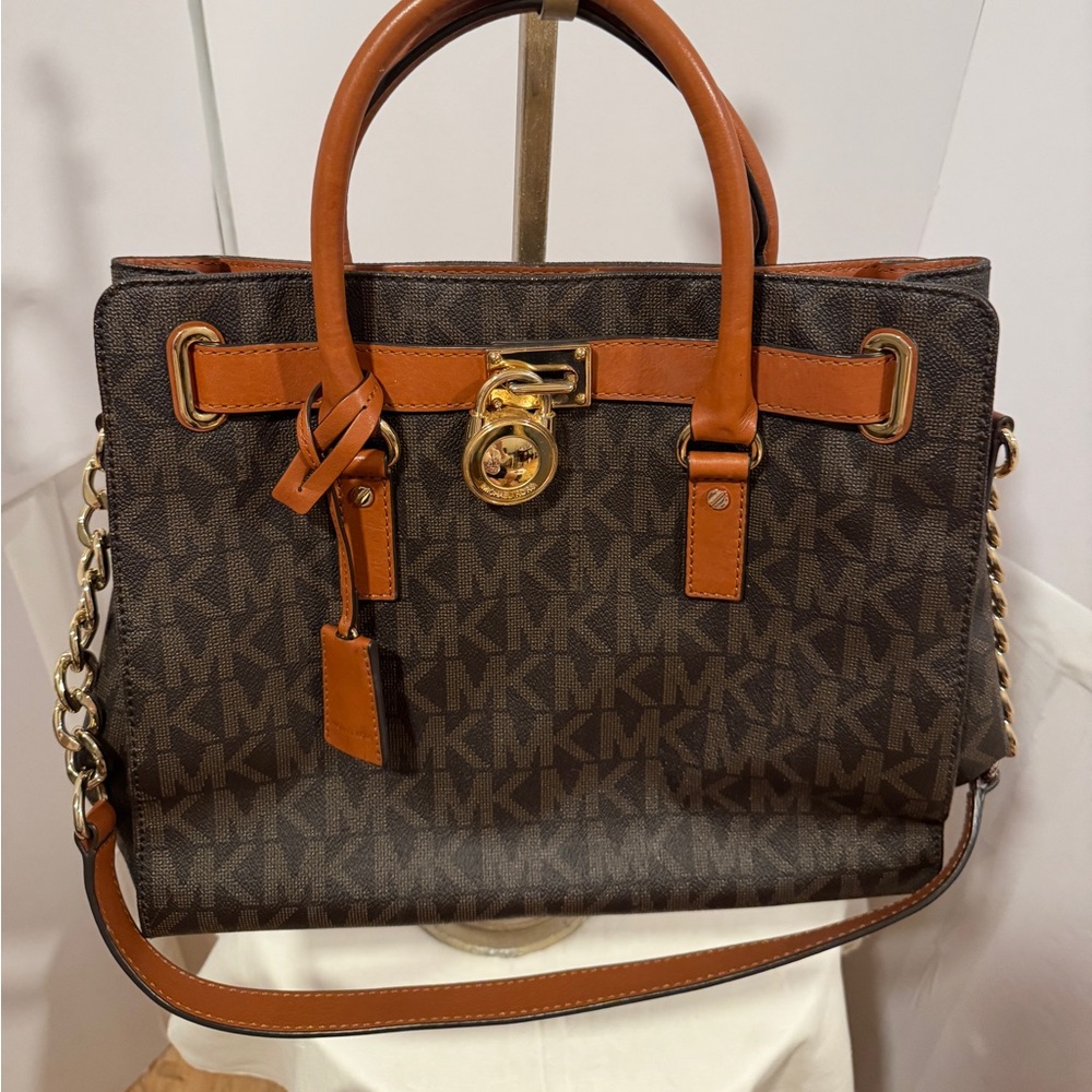 Michael Kors Emblemed satchel style purse. Strap has some gold chain and leather
